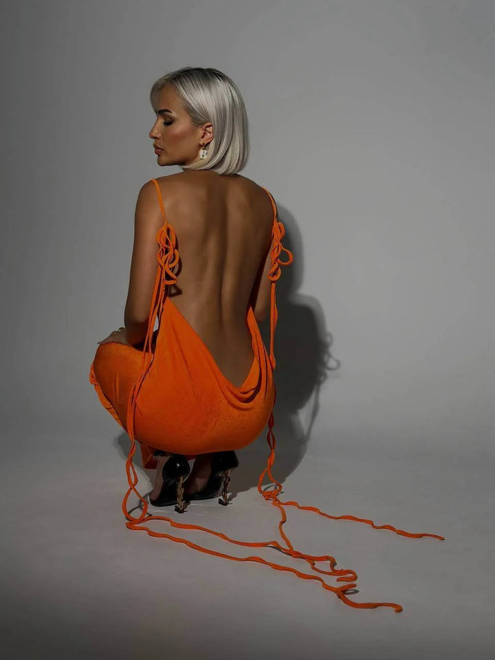 "Orange Karmen backless dress with adjustable ties, sleek modern design, perfect for casual outings or beach days."