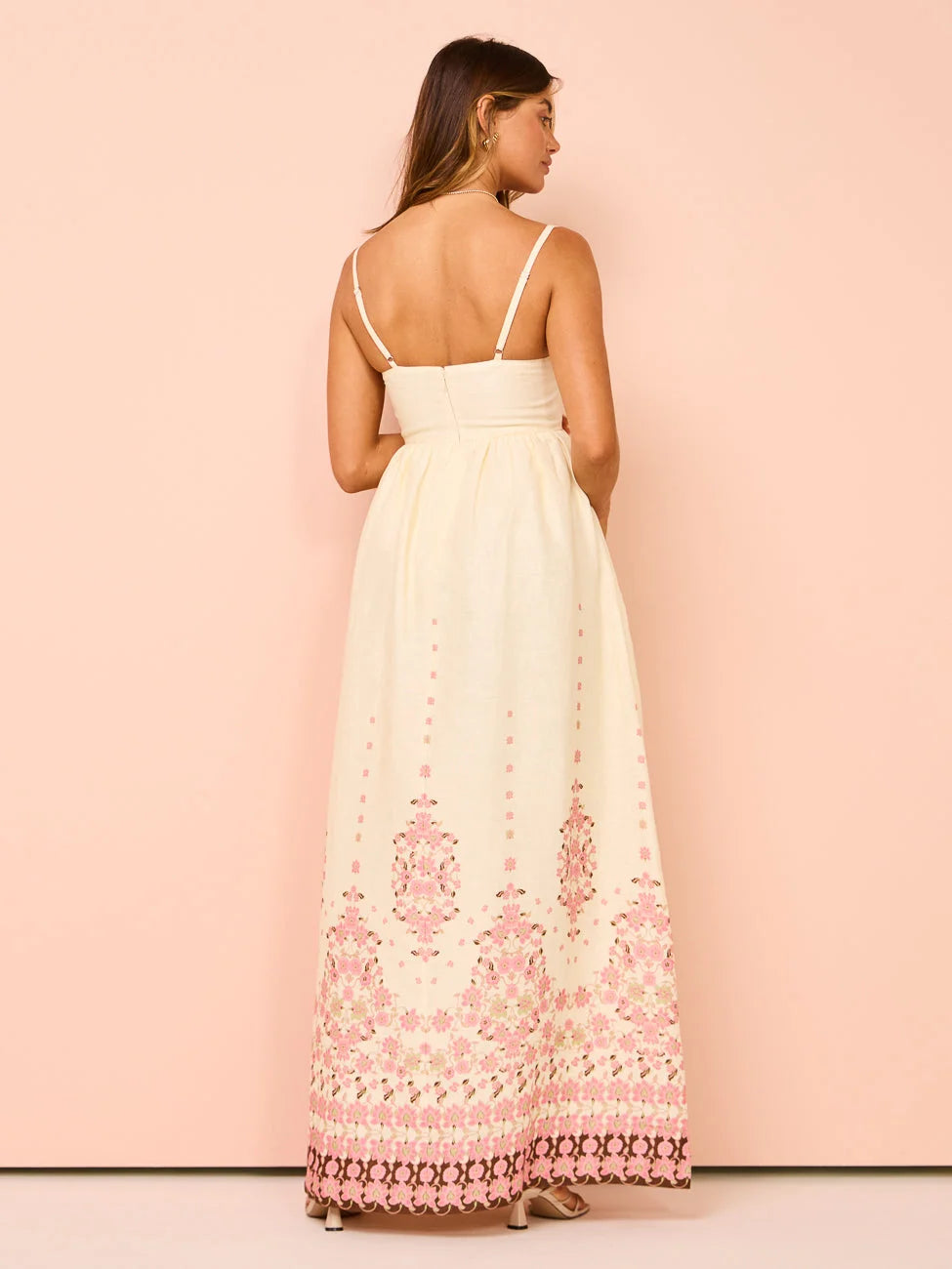 White summer dress with intricate floral pattern hem detail, perfect for a casual outdoor event.