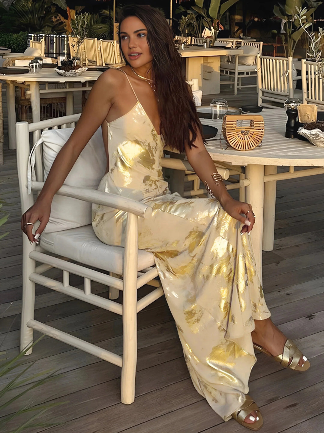 Gold foil satin maxi dress with thin straps, elegant and shimmering design perfect for special occasions.