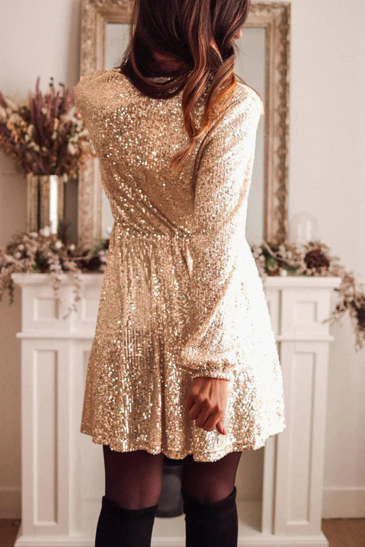 "Aoife gold sequin wrap mini dress with long sleeves, perfect for a glamorous night out."