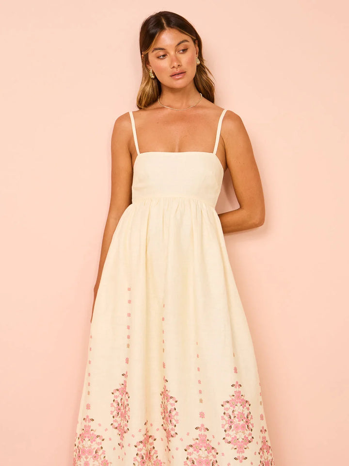 Cream maxi dress with intricate floral embroidery on a soft, flowing fabric perfect for any occasion.