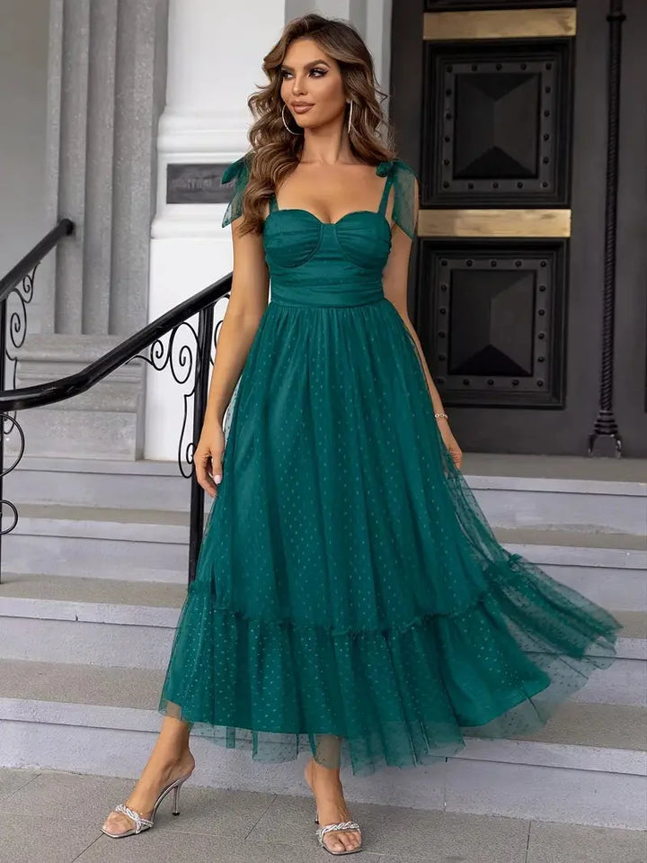 Green mid-length sleeveless dress with white dots design made from soft and breathable fabric.