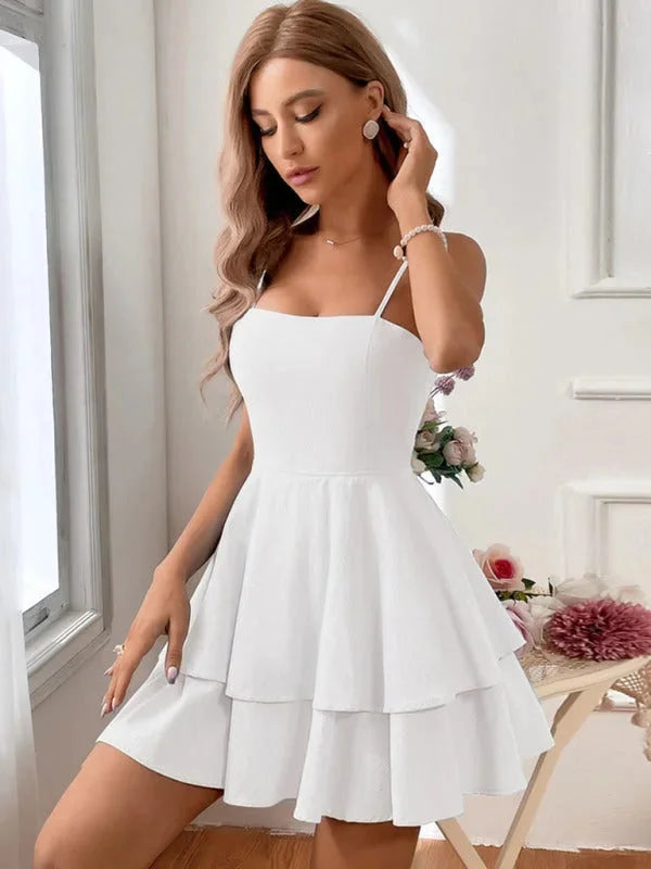 Arwyn tiered mini dress with adjustable straps in soft white cotton fabric, perfect for a casual day out or date night.