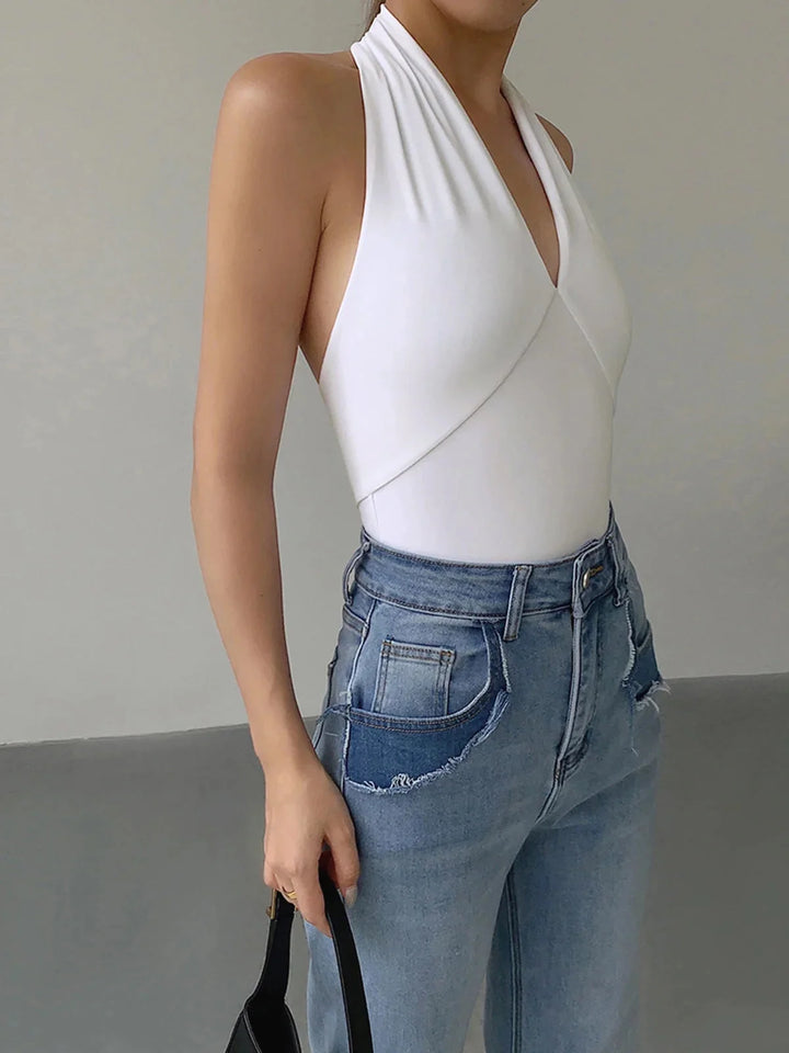 White halter crossover top in a sleek design by Rhythm. Made of soft, stretchy fabric, perfect for casual or dressy outfits.