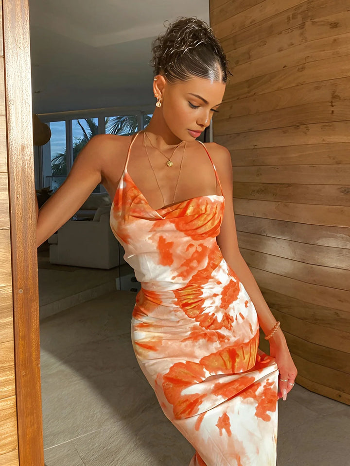 Sleeveless orange floral maxi dress in a soft and flowy fabric with bold blooms, perfect for summer outings or beach days.