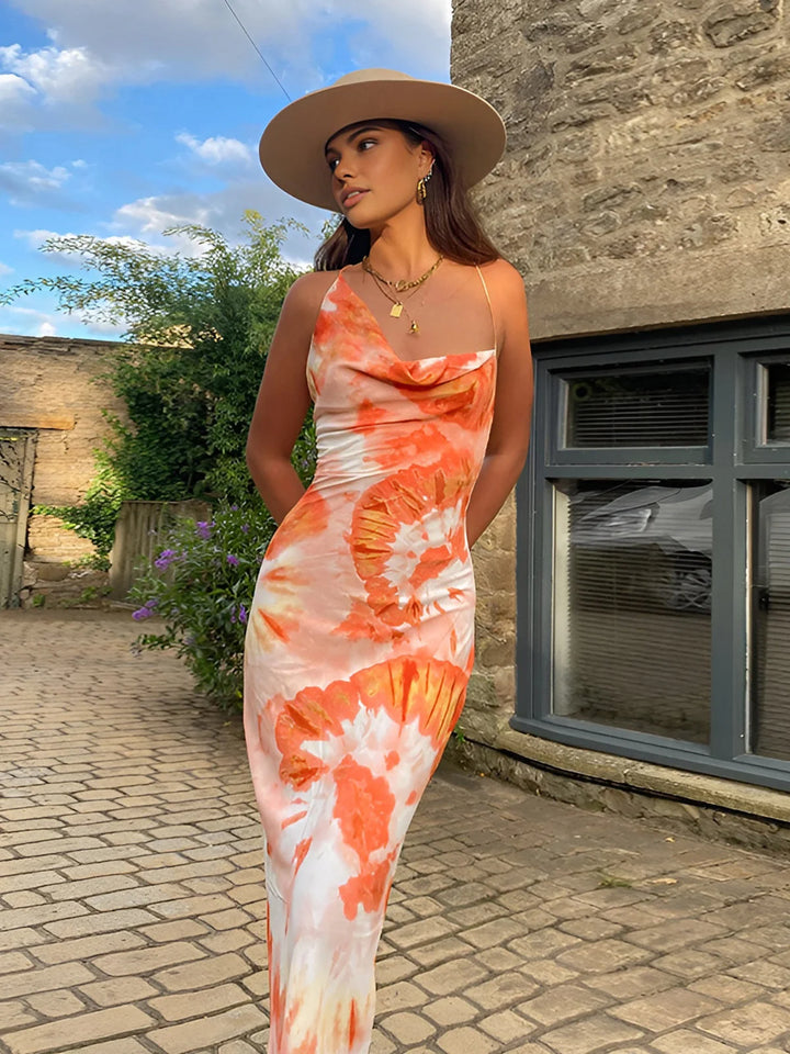 Sleeveless orange floral maxi dress made of lightweight fabric with a vibrant design perfect for summer outings.