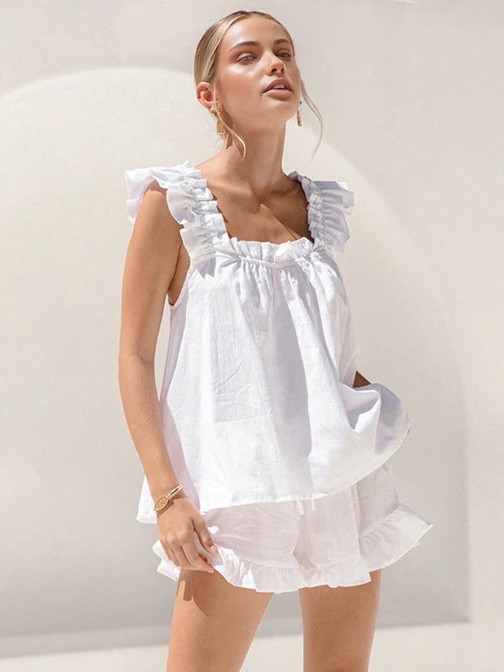 White sleeveless top and matching shorts set with ruffled details. Made from lightweight and breathable fabric perfect for…