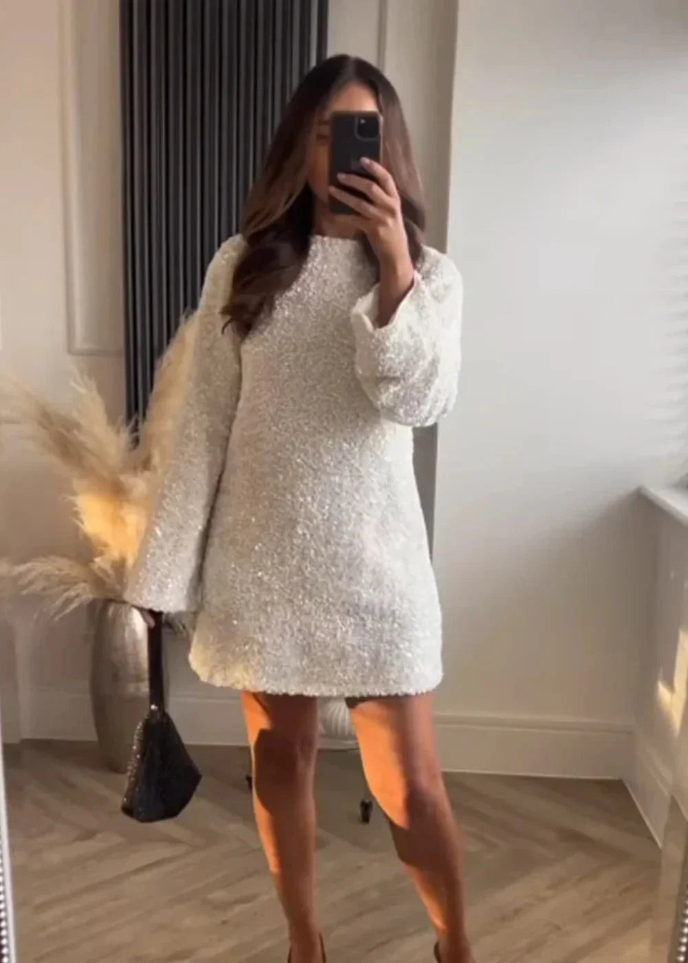 White mini dress with shimmery fabric and chic neckline design by Copelynn.