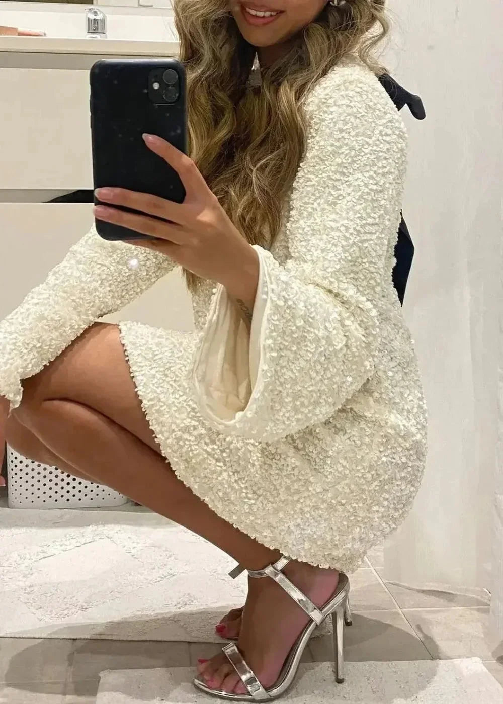 White mini dress featuring elegant neckline detail, sparkling fabric, and sleek design by Copelynn.