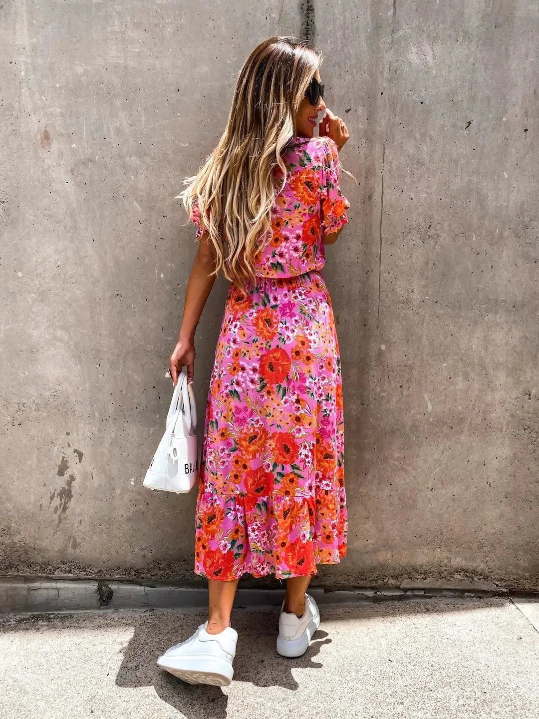 Floral midi dress with intricate wrap front design, featuring vibrant colors and lightweight, flowy fabric by Kasandra.