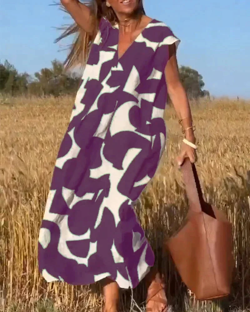 Purple v-neck maxi dress with bold patterns; flowing and comfortable fabric ideal for casual or dressy occasions.