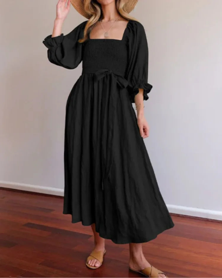 "Navy wrap dress with deep V-neckline and flutter sleeves, made from lightweight and breathable fabric"