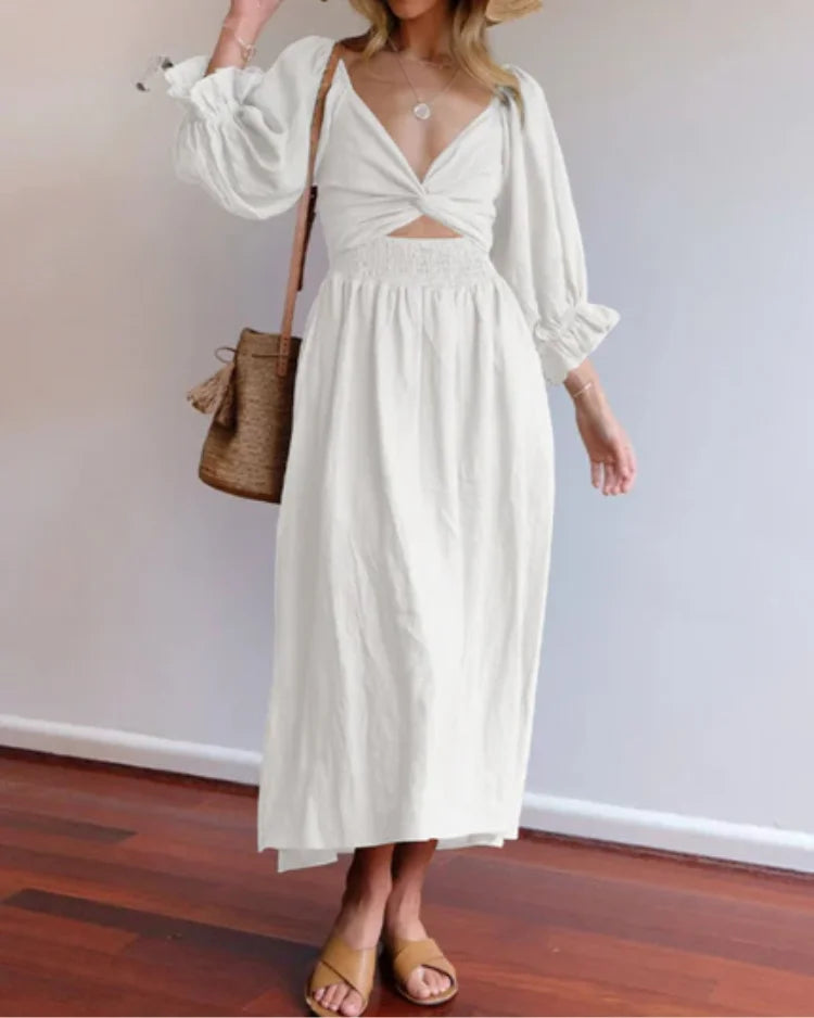 White wrap dress with deep V-neckline by Jessi, made from lightweight cotton blend. Flattering silhouette with elegant…