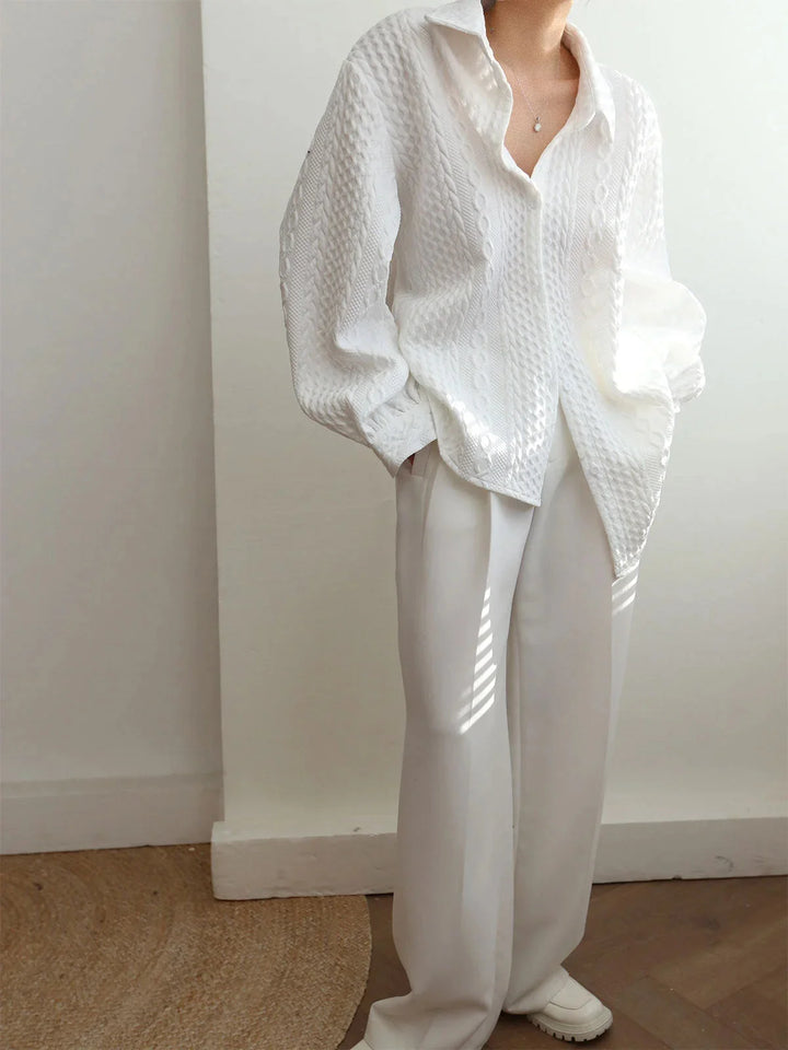 White textured blouse with sculpted sleeves, perfect for adding a chic touch to your outfit.