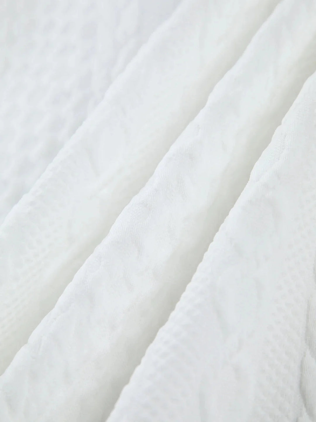 "White blouse with textured fabric and sculpted sleeves, perfect for a stylish and modern look."