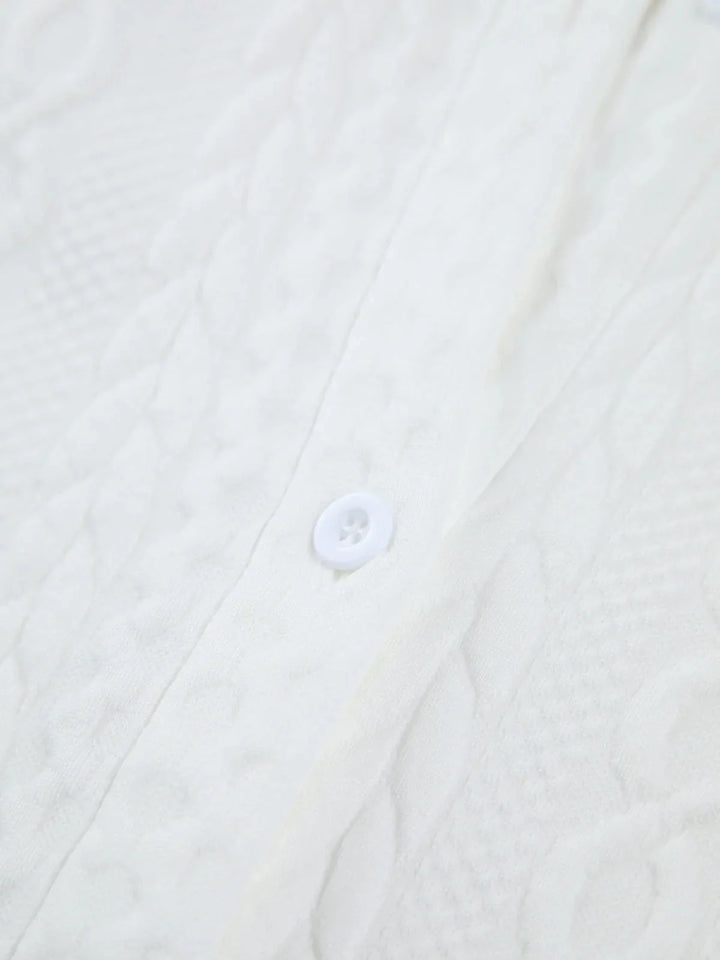 White blouse with textured fabric and sculpted sleeves, perfect for a stylish and sophisticated look.