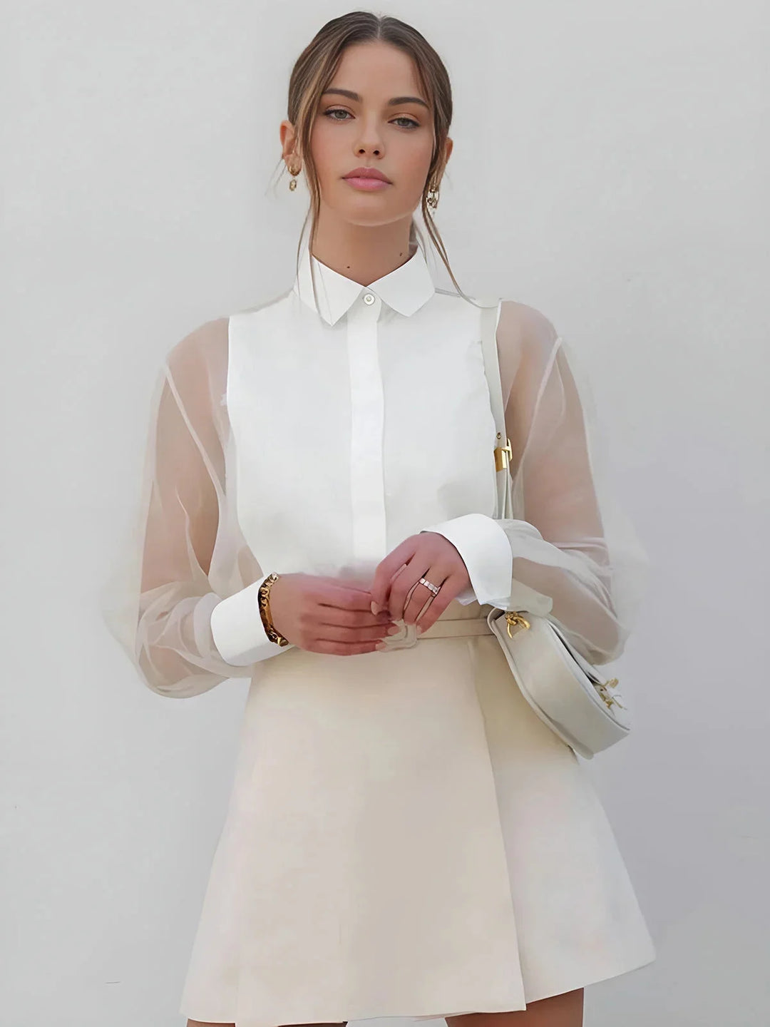 White mini dress with sheer long sleeves and collared neckline by Evie. Elegant and feminine design perfect for any…