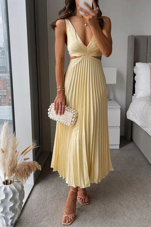 Yellow pleated maxi dress with plunging neckline, perfect for sunny days. Soft and flowy material with elegant design.