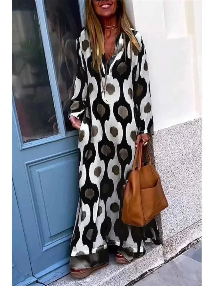 "Zeppelin Maxi Dress: Navy blue long-sleeve V-neck dress with flowy silhouette and pleated details."
