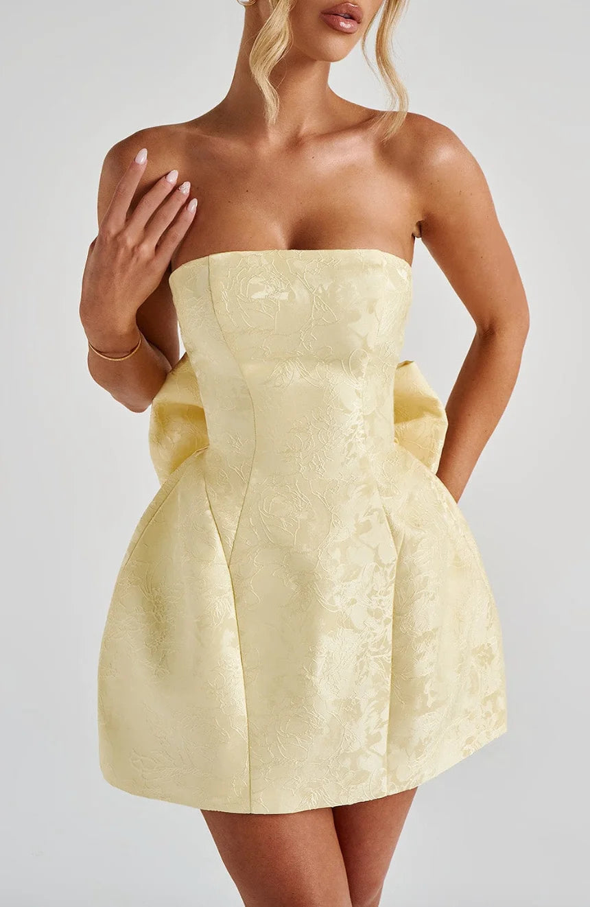 Strapless mini dress in Zoey color with oversized bow detail. Perfect for a fun and flirty look at your upcoming event.