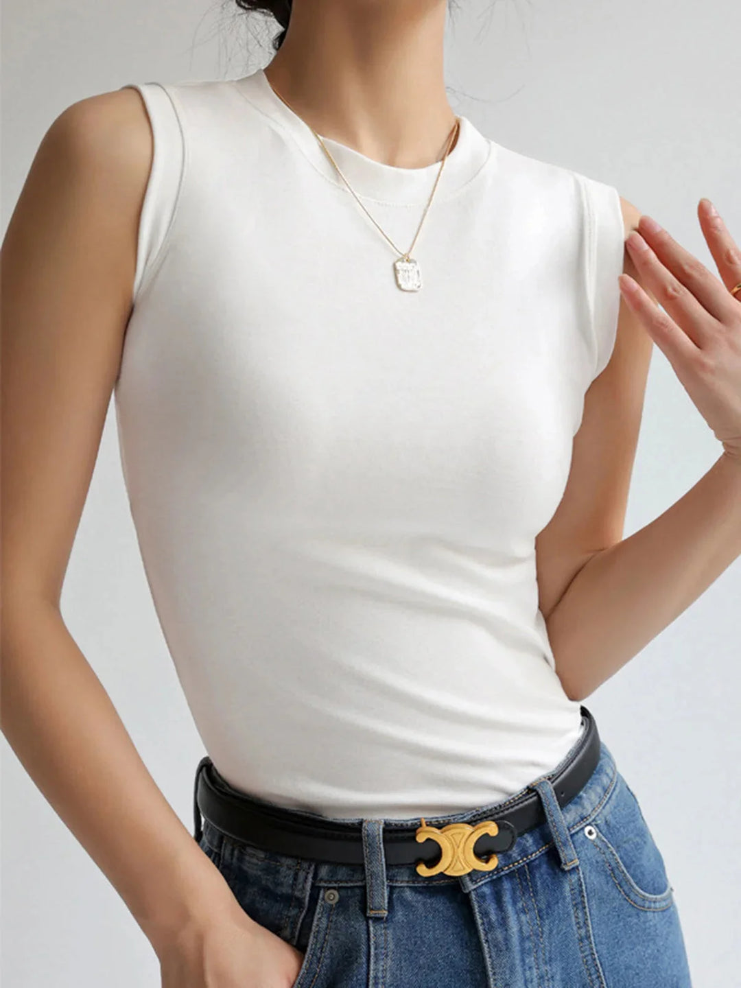 White sleeveless top crafted from soft cotton blend with a chic fitted design, ideal for versatile styling in the Aislinn…
