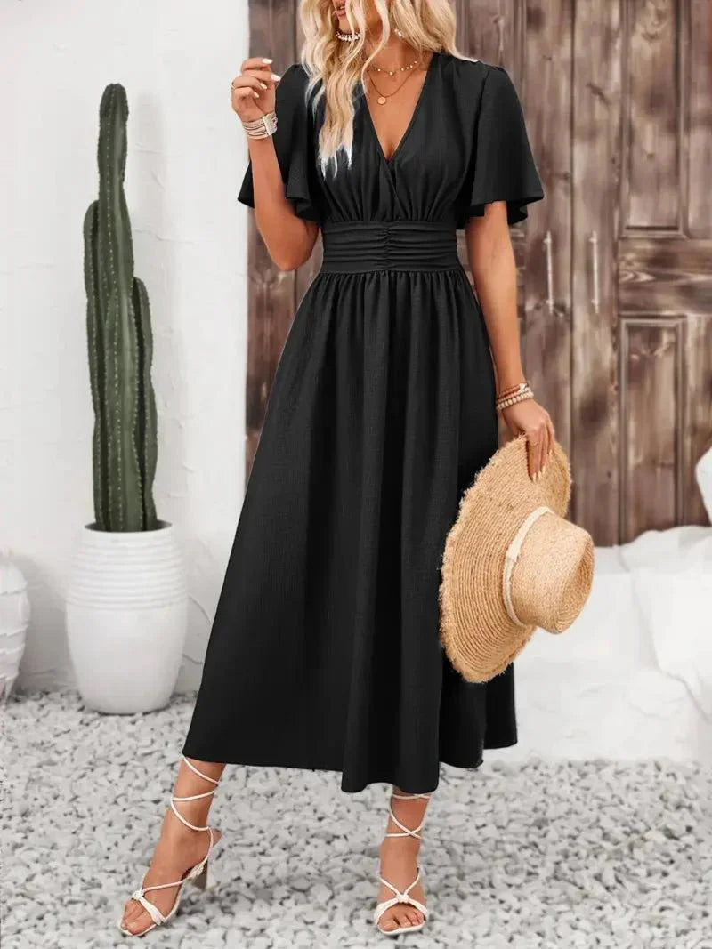 Black V-neck sundress with ruffled sleeves by Rosalinde. Soft cotton blend fabric with a flattering silhouette for a chic…