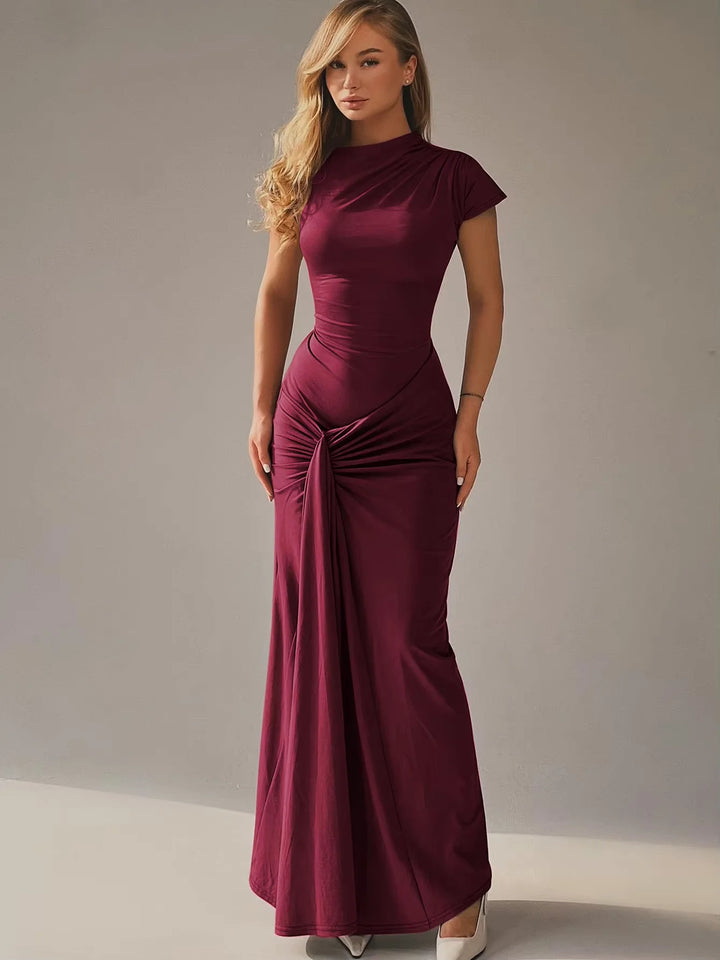 Burgundy maxi dress with ruched detailing, capped sleeves, and flowy silhouette.