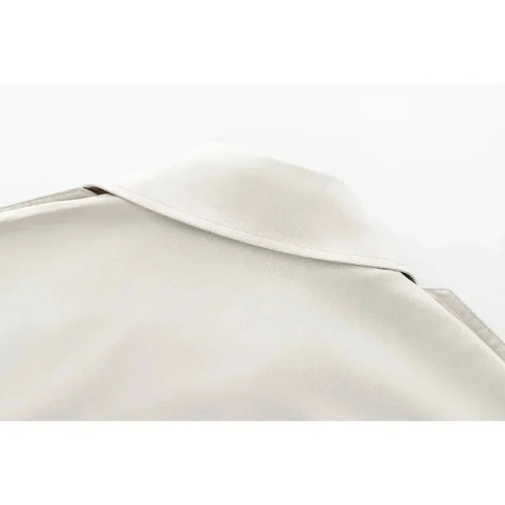 Ivory structured jacket with double-breasted design, tailored fit, and high-quality fabric by Carmela.