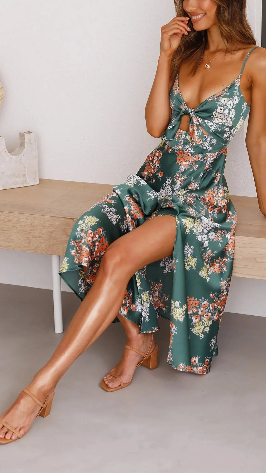 Teal satin dress with floral print and front tie detail, perfect for a chic and stylish look.