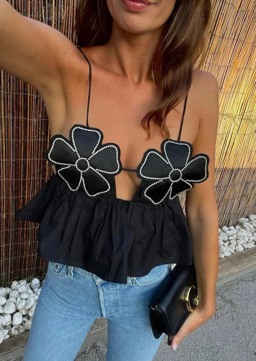 "Aryanna crop top: White floral applique design on black fabric, perfect for a casual yet chic look."