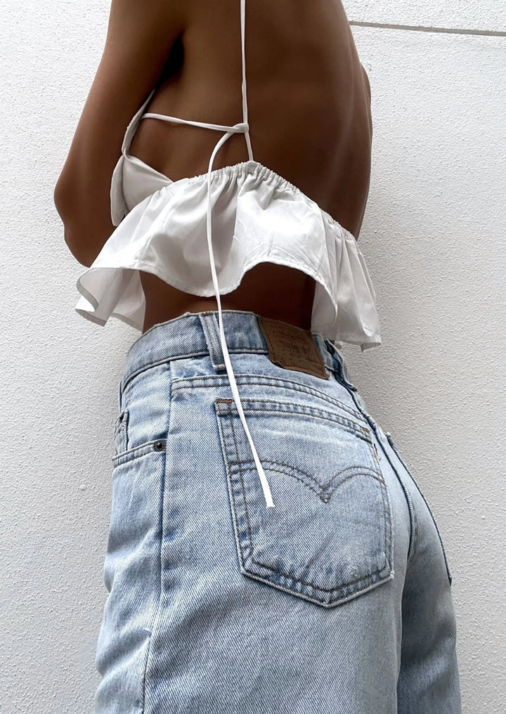 White crop top with delicate floral appliques and sheer mesh fabric. Feminine and elegant design for women's casual or…