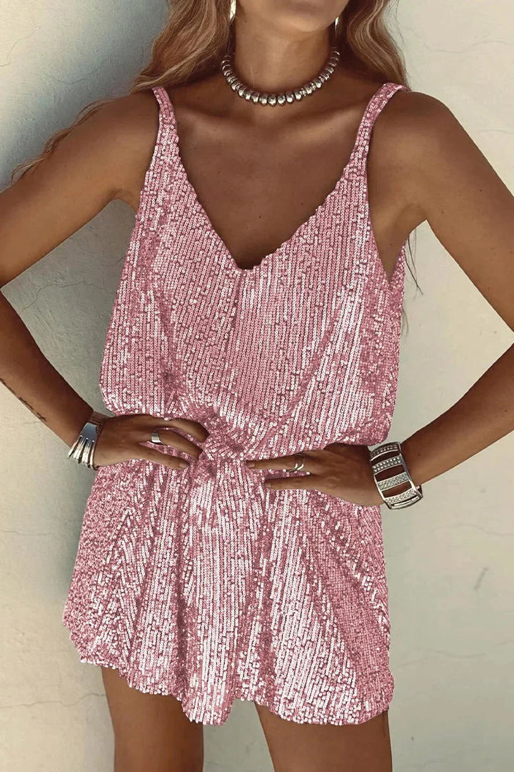 Pink sequin V-neck romper with a sleeveless silhouette. Glamorous and shimmering design perfect for a night out or special…