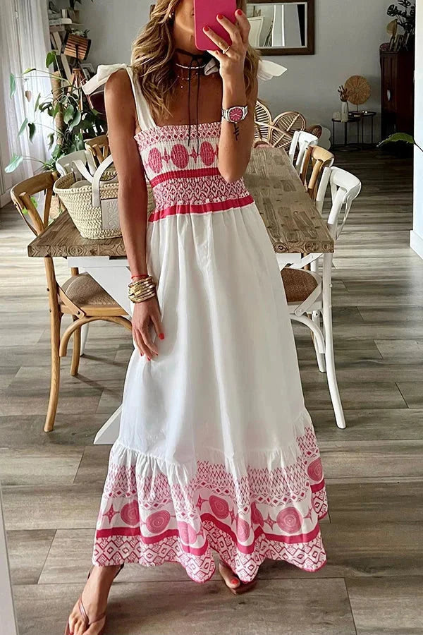 White maxi dress featuring pink tribal patterns on a light, airy fabric, perfect for summer days or beach trips.