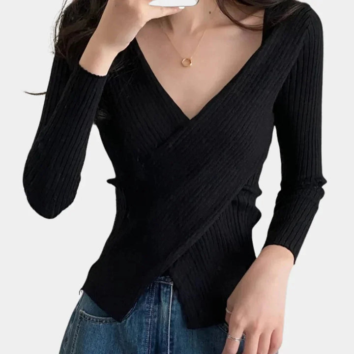 Black ribbed V-neck wrap top by Raquel. Soft, stretchy fabric with a chic wrap design for a trendy and versatile look.