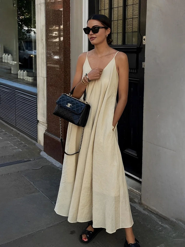Apricot flowy maxi dress with V-neck and layered design, perfect for casual or special occasions.