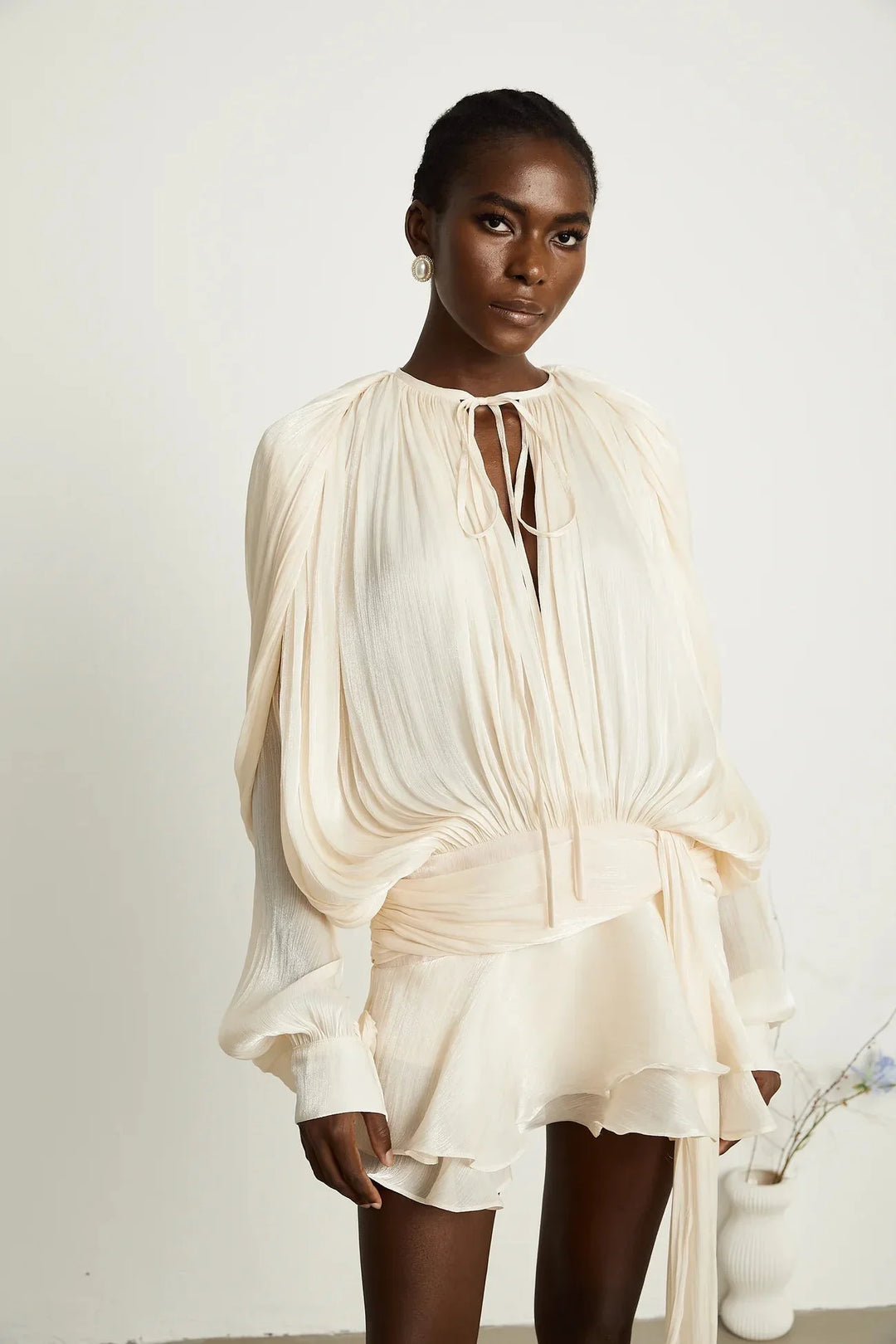 "Satin mini dress in Camiyah style with tie accents, flowing silhouette."