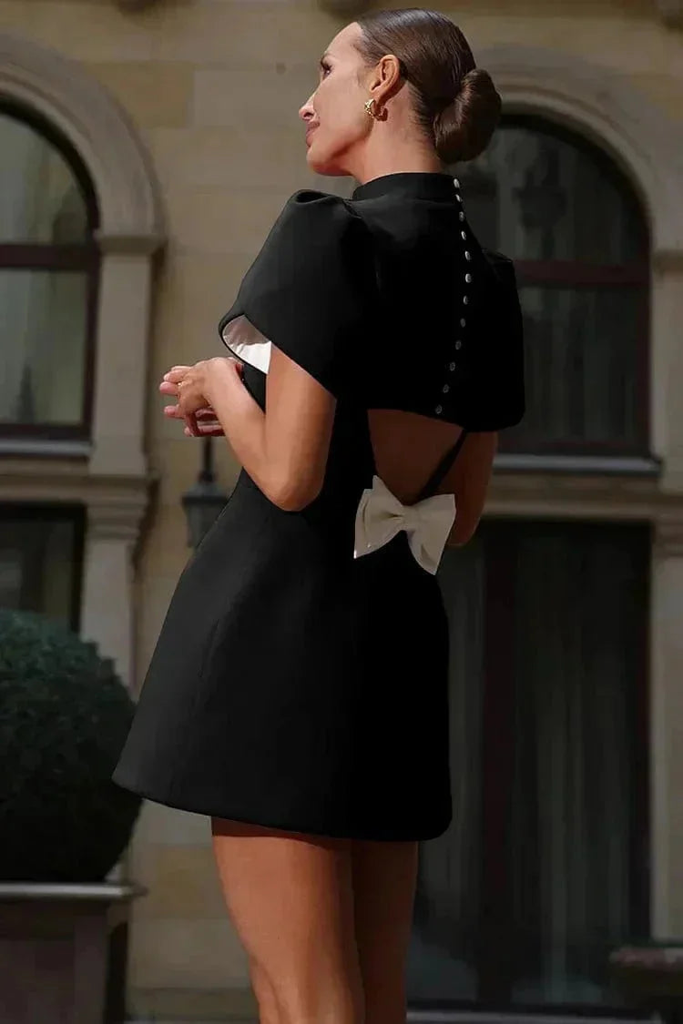Black mini dress with structured ruffled sleeves in light fabric. Chic and elegant design perfect for any occasion.