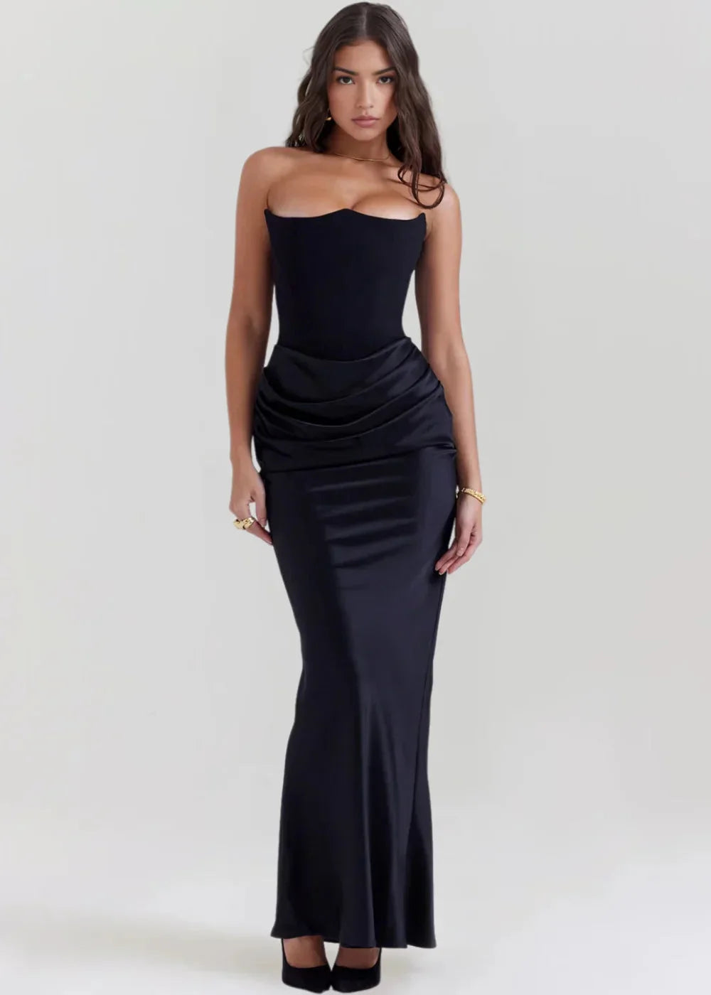 Black strapless gown by Wrenly, featuring a sleek design. Crafted from a soft, lustrous fabric with a tailored fit for…