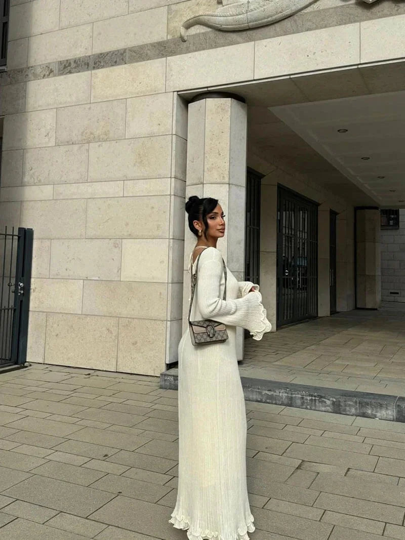 "Black floor-length dress with pleats and bell sleeves, perfect for special occasions."