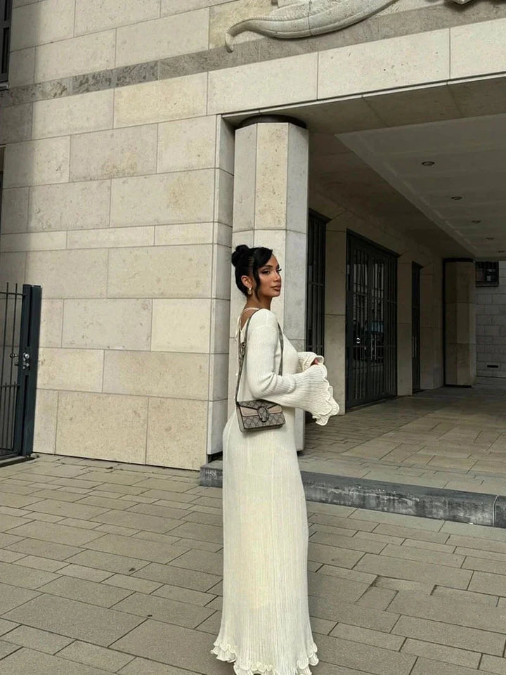 "Black floor-length dress with pleats and bell sleeves, perfect for special occasions."