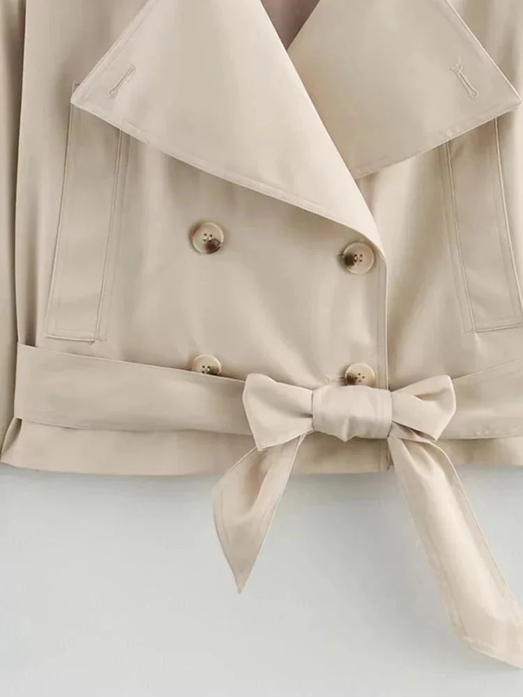 "Beige cropped jacket with waist tie, featuring a chic design and made of soft, comfortable fabric."