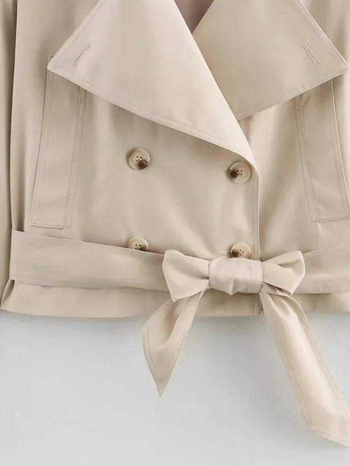 "Beige cropped jacket with waist tie, featuring a chic design and made of soft, comfortable fabric."