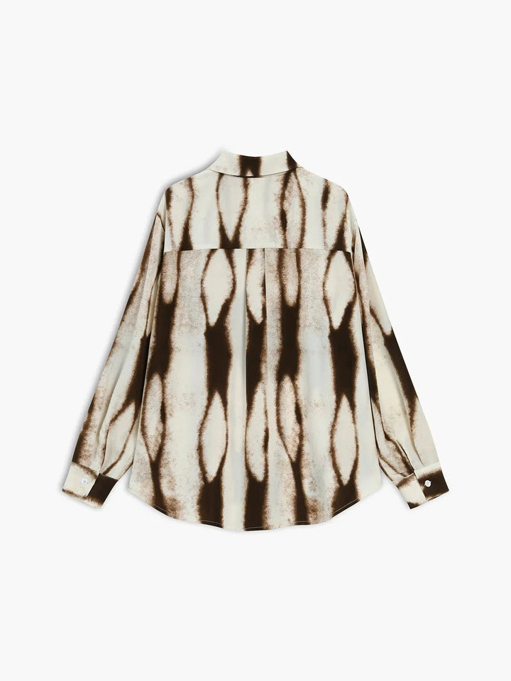 Abstract print button-up blouse by Alaska. Features a stylish and unique design with a blend of polyester and viscose fabrics.