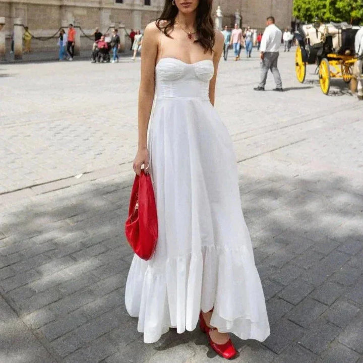 White maxi dress with ruched bodice, made of soft and flowy fabric. Perfect for a casual day out or special occasion.