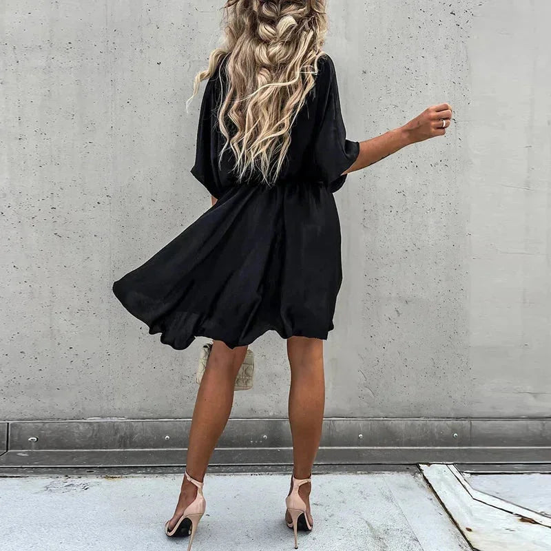 "Leandra flowy V-neck mini dress in soft, lightweight fabric with elegant design for casual or formal occasions."