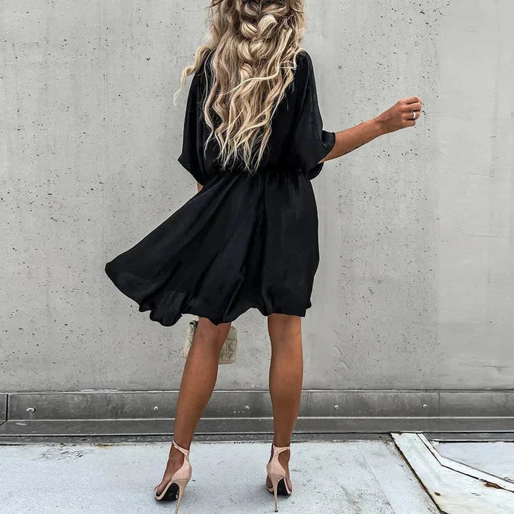 "Leandra flowy V-neck mini dress in soft, lightweight fabric with elegant design for casual or formal occasions."