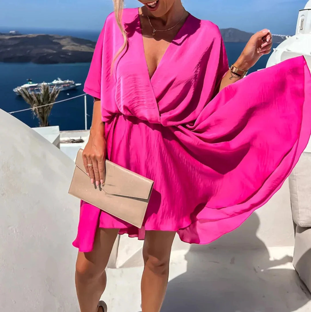 Flowy v-neck mini dress in soft Leandra color with flutter sleeves and a ruffled hem, perfect for summer days or special…