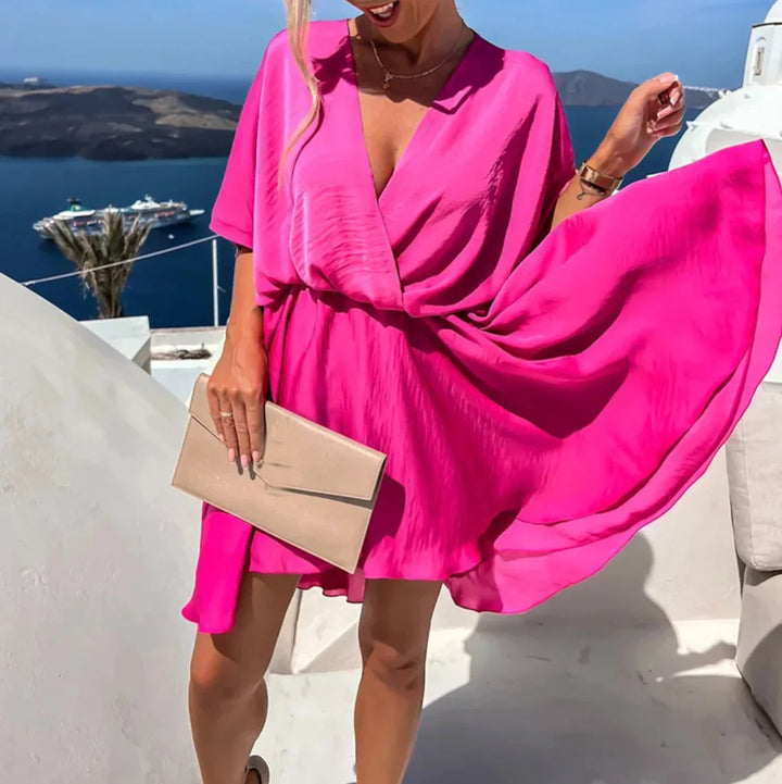 Flowy v-neck mini dress in soft Leandra color with flutter sleeves and a ruffled hem, perfect for summer days or special…