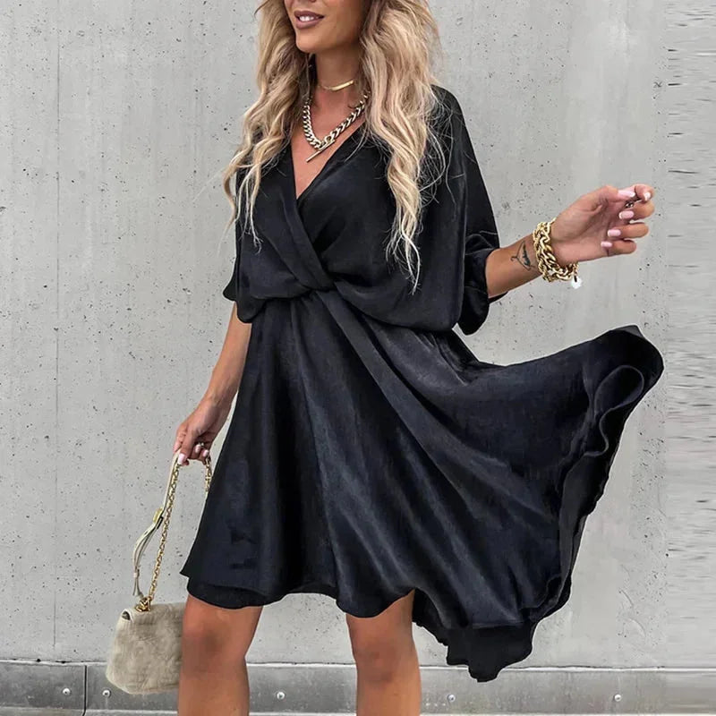 Black flowy V-neck mini dress made of lightweight fabric. Features delicate Leandra print on a relaxed silhouette.