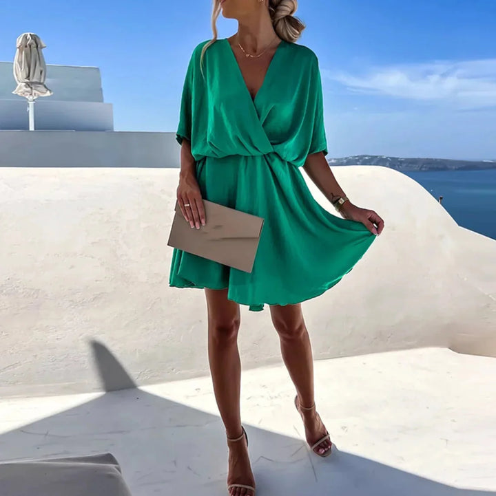 Green flowy V-neck mini dress made with lightweight fabric. Features delicate Leandra print perfect for casual gatherings or…